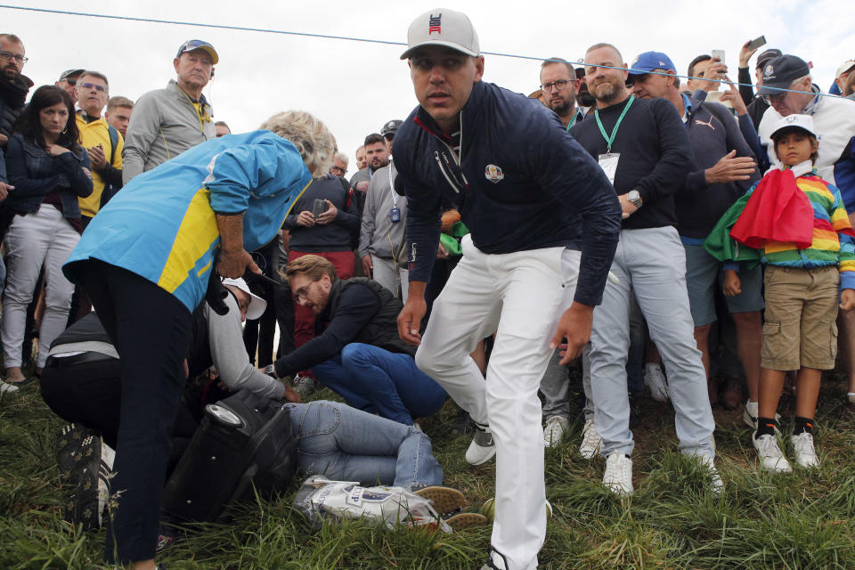 FILE - In this Friday, Sept. 28, 2018 file photo Brooks Koepka of the US offers a golf glove to a spectator he injured when his ball hit her on the 6th hole during his fourball match on the opening day of the 42nd Ryder Cup at Le Golf National in Saint-Quentin-en-Yvelines, outside Paris, France. Ryder Cup organizers say they are alarmed by the news that a spectator hit by a Brooks Koepka's tee shot at the Ryder Cup says she has lost sight in her right eye. (AP Photo/Francois Mori, File