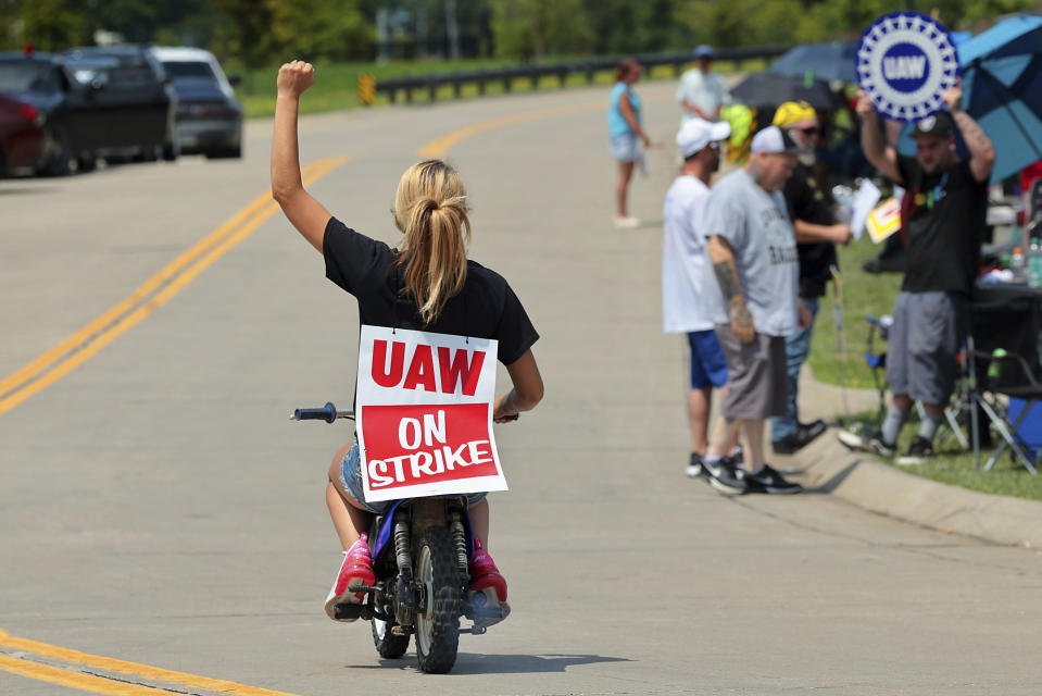 Lear production worker Abigail Fletcher rides her mini bike in support of the picket line as members of United Auto Workers Local 282 continue their strike against the car and truck seat manufacturer in Wentzville, Mo. on Tuesday, July 23, 2024. The strike led to a shutdown at the nearby GM assembly plant. (Robert Cohen/St. Louis Post-Dispatch via AP)