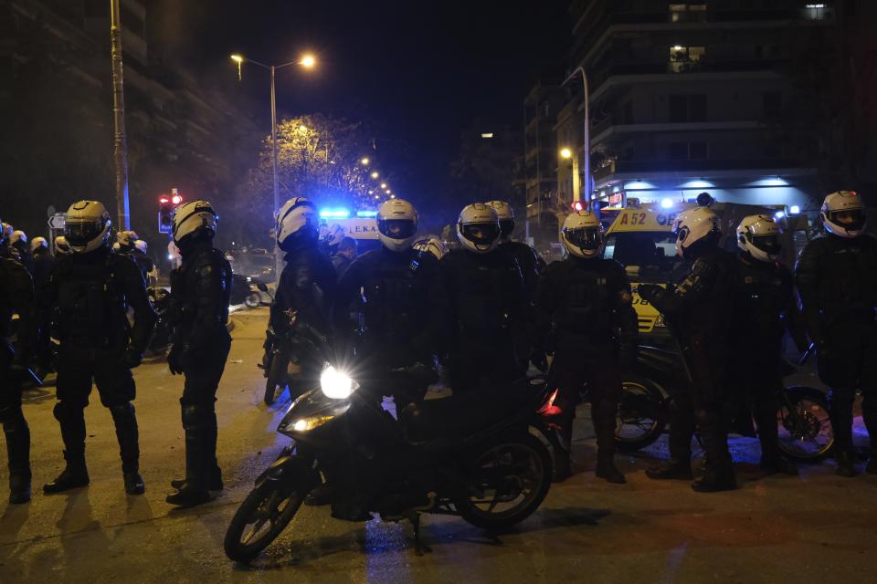 Policemen gather around their injured colleague after an attack by protesters during clashes in Athens, Tuesday, March 9, 2021. Severe clashes broke out Tuesday in Athens after youths protesting an incident of police violence attacked a police station with petrol bombs, and severely injured one officer. (AP Photo/Aggelos Barai)
