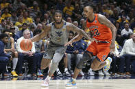 West Virginia guard Joe Toussaint (5) dribbles as Auburn guard Allen Flanigan (22) defends during the second half of an NCAA college basketball game on Saturday, Jan. 28, 2023, in Morgantown, W.Va. (AP Photo/Kathleen Batten)