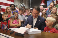 Virginia Gov. Glenn Youngkin signs the budget at a ceremony at a grocery store Tuesday June 21, 2022, in Richmond, Va. The Virginia General Assembly passed the budget earlier in the week. (AP Photo/Steve Helber)