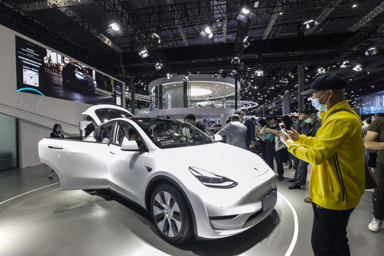 Visitors look at a China-made Tesla Inc. Model Y electric vehicle at the Auto Shanghai 2021 show in Shanghai, China, on Tuesday, April 27, 2021.  Photographer: Qilai Shen/Bloomberg