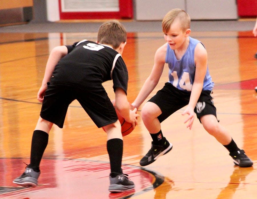 Andrew Jos (14) of the Falcons has his eyes on the ball while playing relentless defense against the Spurs' Lucas Wolfe (9). This exciting action was culled from a recent Honesdale Biddy Basketball Association Junior Division game at Lakeside Elementary.