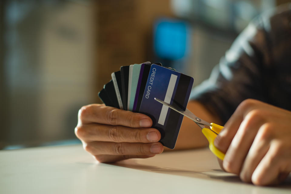 Young man cutting credit card with scissors,Man is destroying credit cards because of big debt.