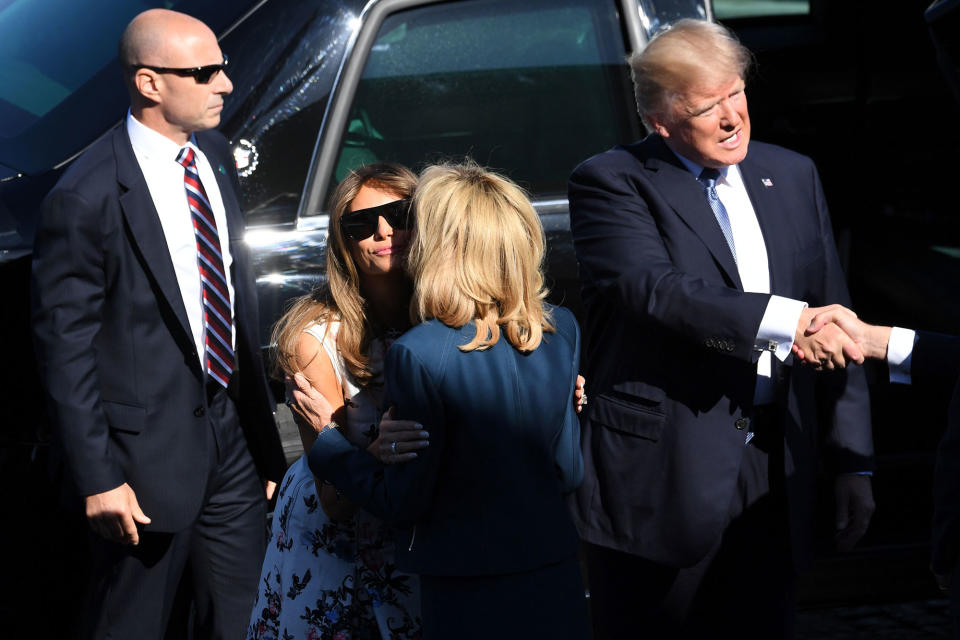 <p>President Donald Trump (R) shakes hands as he steps out of the presidential state car called “The Beast” as First Lady Melania Trump (L) kisses Brigitte Macron, wife of French President, ahead of the start of the annual Bastille Day military parade on the Champs-Elysees avenue in Paris on July 14, 2017. (Photo: Alain Jocard/AFP/Getty Images) </p>