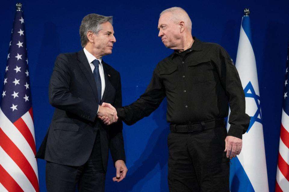 Israeli Defense Minister Yoav Gallant, right, and Secretary of State Antony Blinken shake hands prior to a meeting in Tel Aviv, Israel, on Nov. 30, 2023. Blinken told Israeli leaders on Nov. 30 that a temporary truce in their war with Hamas was "producing results" and should continue.