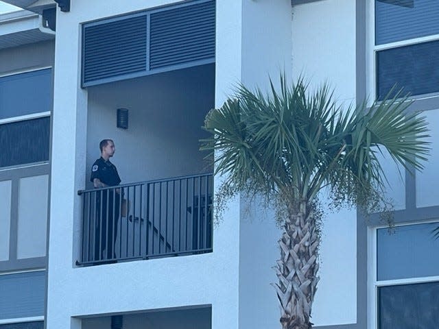 A Fort Myers police officer stands watch Thursday morning at the Fort Myers apartment where Fort Myers police said they were met with gunfire Wednesday night.