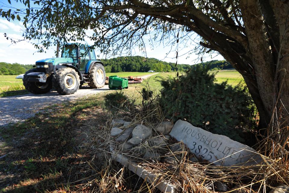 A New Holland farm tractor and overturned trash can block the long driveway to Larry Householder's Perry County farm house. Shortly after he was arrested, Perry County Sheriff's deputies manned a cruiser to keep sightseers and the media away from the house.