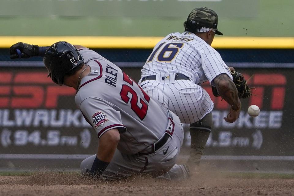 Atlanta Braves' Austin Riley is safe at second as Milwaukee Brewers' Kolten Wong can't handle the throw during the eighth inning of a baseball game Sunday, May 16, 2021, in Milwaukee. (AP Photo/Morry Gash)