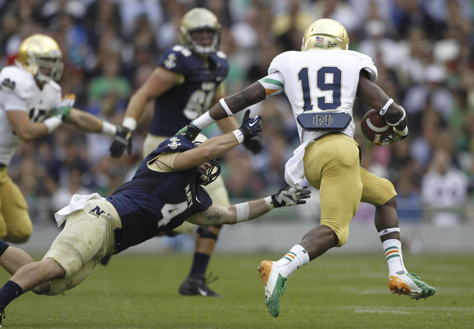 FILE - Notre Dame's Davonte Neal, right, holds off a challenge from the Navy's Bo Snelson, left, during their NCAA college football game in Dublin, Ireland, Sept. 1, 2012. Notre Dame will face Navy in Dublin, Ireland, for their season opener on Saturday, Aug. 26, 2023. (AP Photo/Peter Morrison, File)