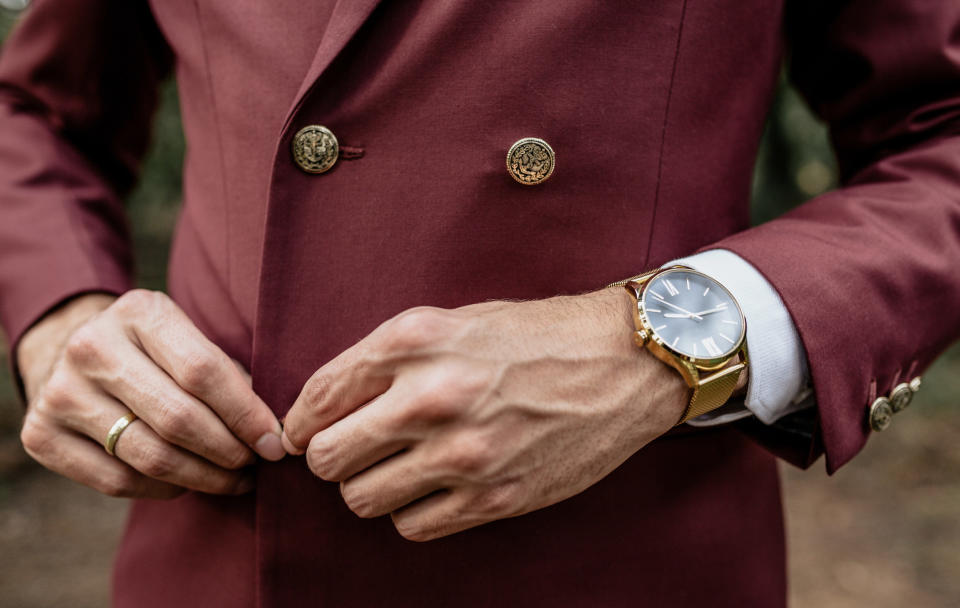 A man buttoning his jacket