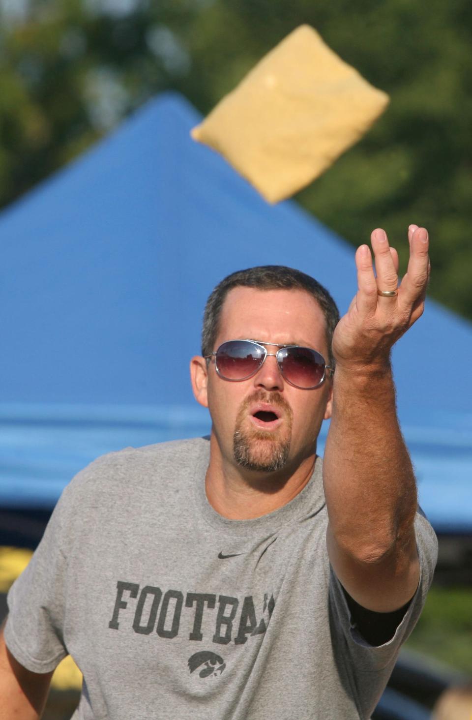 Iowa fan John Barnes of Cedar Rapids tosses his bag while playing cornhole before a football game.