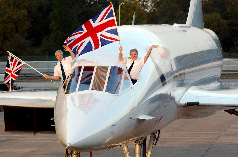 Captain Mike Bannister (R) and Senior First Officer Jonathan Napier (L) wave from the cockpit as the British Airways Concorde lands at London's Heathrow Airport, on the day that the world's first supersonic airliner retired from commercial service. Thousands of people gathered at the airport to see three of the aircraft land one after the other.   (Photo by Sean Dempsey - PA Images/PA Images via Getty Images)