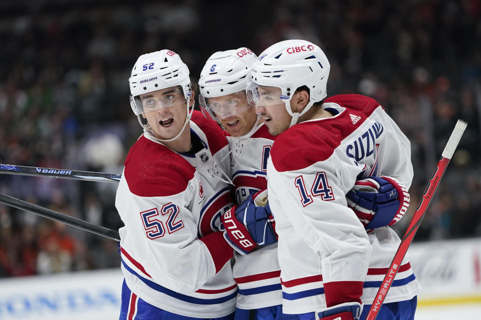 Montreal Canadiens defenseman Mike Matheson, center, is congratulated by defenseman Justin Barron, left, and center Nick Suzuki after his goal against the Anaheim Ducks during the second period of an NHL hockey game Wednesday, Nov. 22, 2023, in Anaheim, Calif. (AP Photo/Ryan Sun)