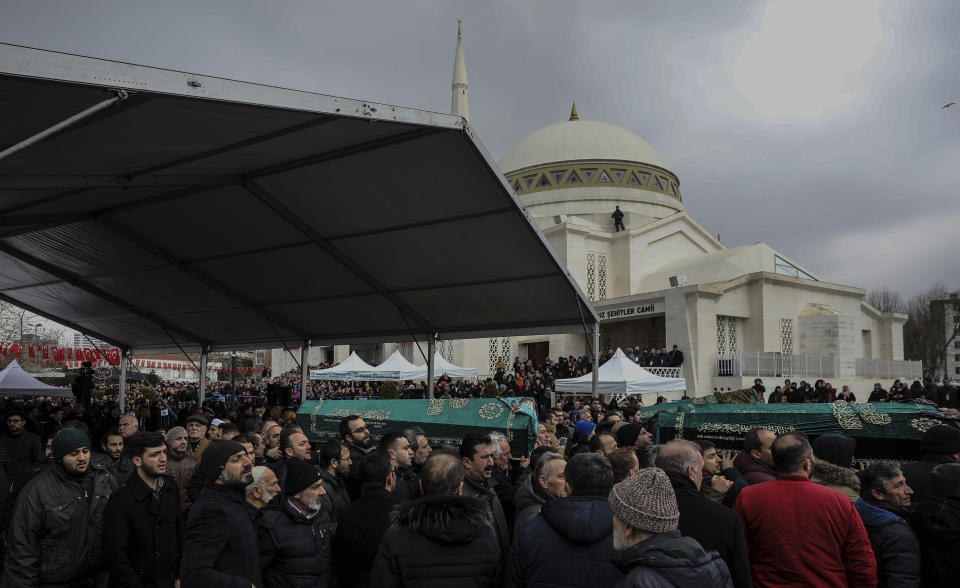 People carry coffins as hundreds of mourners attend the funeral prayers for nine members of Alemdar family killed in a collapsed apartment building, in Istanbul, Saturday, Feb. 9, 2019. Turkey's President Recep Tayyip Erdogan says there are "many lessons to learn" from the collapse of a residential building in Istanbul where at least 17 people have died.(AP Photo/Emrah Gurel)