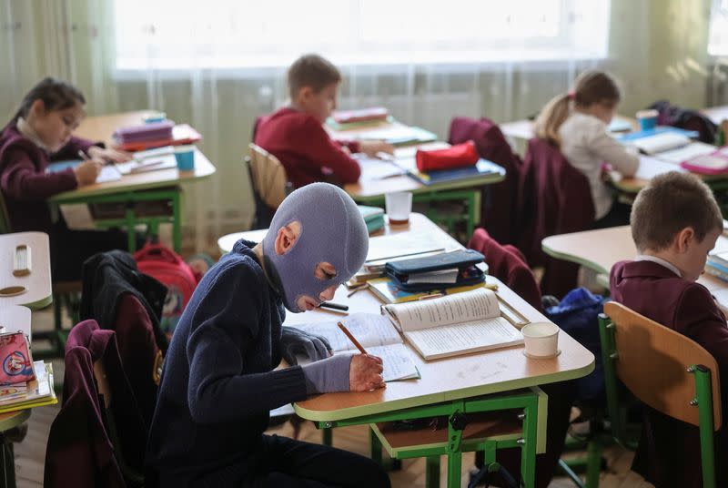Roman, wounded by Russian missile strike last year, wears a burn mask as he attends school, in Lviv