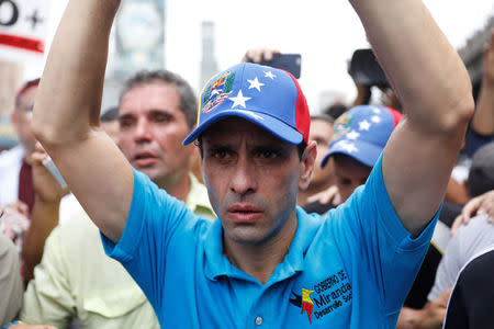 Opposition leader Henrique Capriles raises his arms as he reacts after being exposed to tear gas during an opposition rally in Caracas,, Venezuela April 6, 2017. REUTERS/Carlos Garcia Rawlins