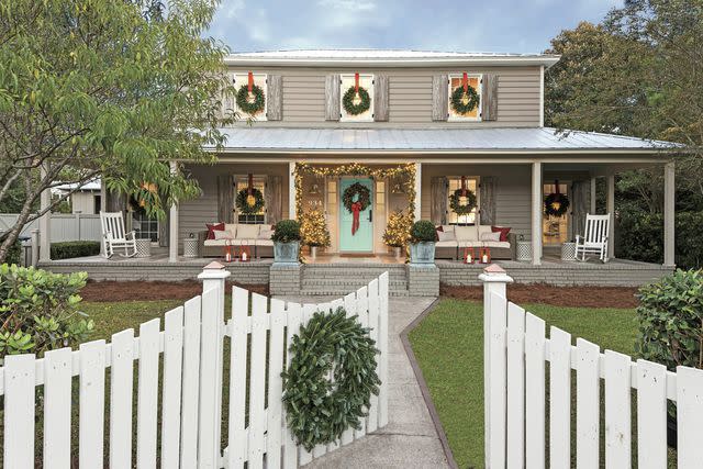 This inviting home uses dimensional layering techniques, like wreaths, bows, and lights, to create a festive display.