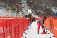 <p>A volunteer arranges the snow near the public area of the Men’s Downhill 2nd training at the Jeongseon Alpine Center during the PyeongChang 2018 Winter Olympic Games in PyeongChang on February 9, 2018. (Martin Bernetti/AFP/Getty Images) </p>