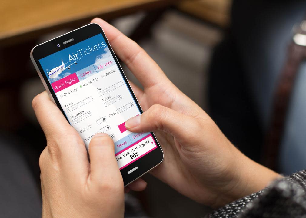 A girl using a phone to book plane tickets.