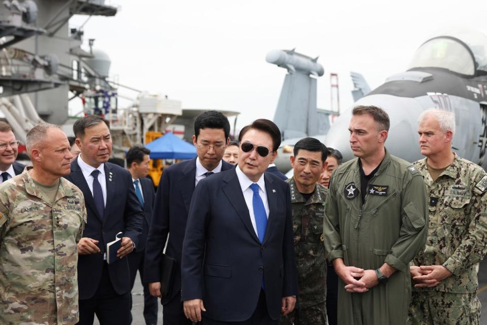 Yoon Suk Yeol boards the USS Theodore Roosevelt aircraft carrier at the South Korean naval base in Busan on 25 June 2024 (AP)