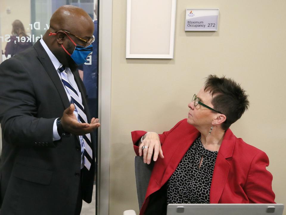 N.J. Akbar, Akron Public Schools board president, talks with Ellen McWilliams-Woods, the district's chief academic officer/assistant superintendent for curriculum and instruction, during a break at Monday's board meeting.