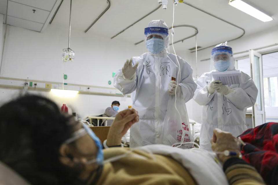 Medical workers check on the conditions of patients in Jinyintan Hospital, designated for critical COVID-19 patients, in Wuhan in central China's Hubei province Thursday, Feb. 13, 2020. China on Thursday reported 254 new deaths and a spike in virus cases of 15,152, after the hardest-hit province of Hubei applied a new classification system that broadens the scope of diagnoses for the outbreak, which has spread to more than 20 countries. (Chinatopix Via AP)