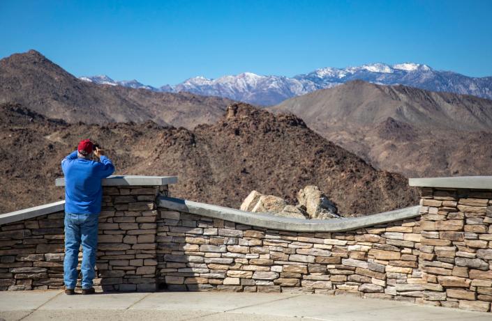 John Hess of Palm Desert takes a break from a ride on his Harley-Davidson motorcycle to take in the view of the snowcapped mountains from the Coachella Valley Vista Point along Highway 74 in Palm Desert, Calif., Tuesday, March 1, 2022.