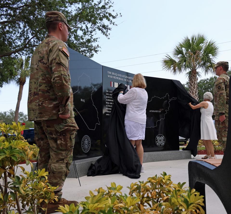 Gold Star mothers Kim Allison (left) and Michele Carey unveil a monument designed to honor Floridians who served in our nation's wars in Iraq and Afghanistan during a ceremony at Veterans Memorial Park on Saturday, April 20, 2024, in Port St. Lucie. The 349 names of Floridians who were killed in each war is listed on the monument. The monument is the first in Florida to honor the individual military personnel lost in these wars. Gold Star mothers lost sons or daughters in service of the United States Armed Forces.