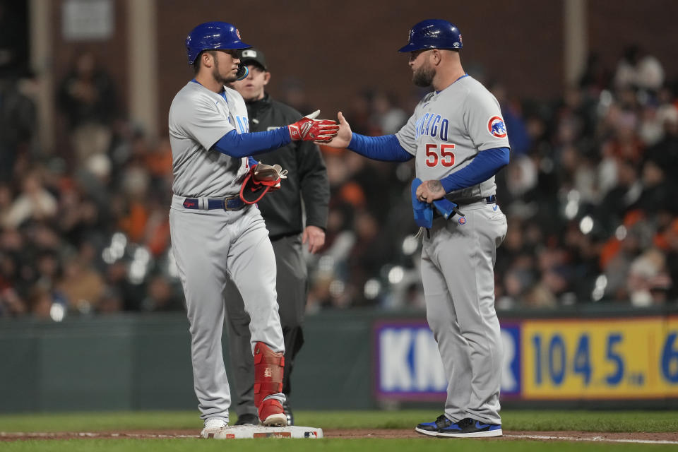 Chicago Cubs' Seiya Suzuki, left, is congratulated by first base coach Mike Napoli after hitting a single against the San Francisco Giants during the eighth inning of a baseball game in San Francisco, Friday, June 9, 2023. (AP Photo/Jeff Chiu)