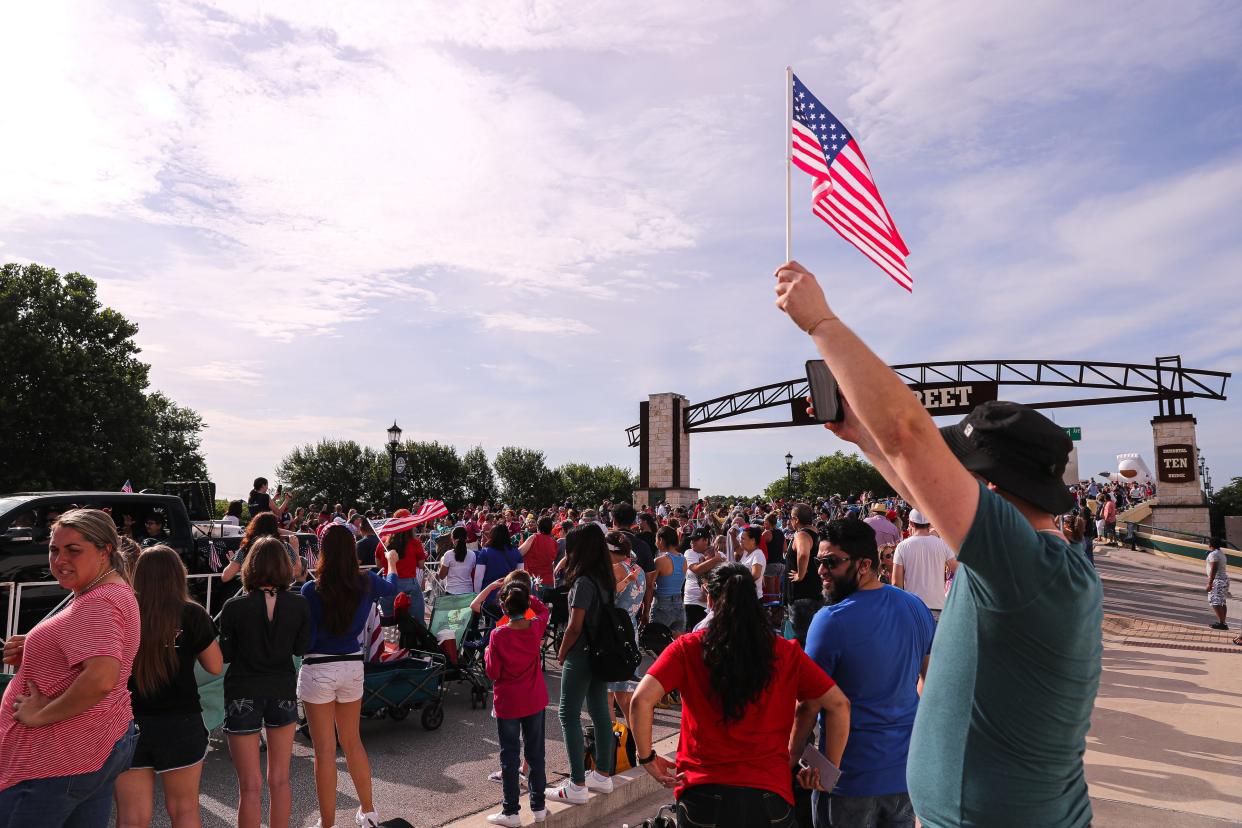 A spectator waves an American flag at the annual Sertoma Independence Day Parade in Round Rock last year.