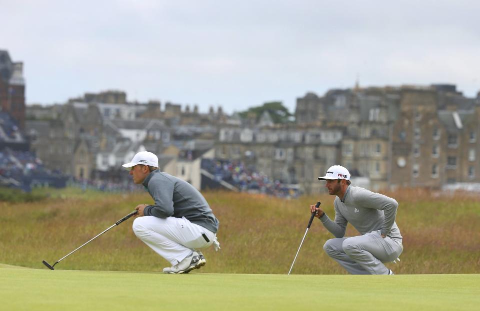 Jordan Spieth of the U.S. (L) and his compatriot Dustin Johnson line up their putts on the 16th green during the first round of the British Open golf championship on the Old Course in St. Andrews, Scotland, July 16, 2015. REUTERS/Eddie Keogh