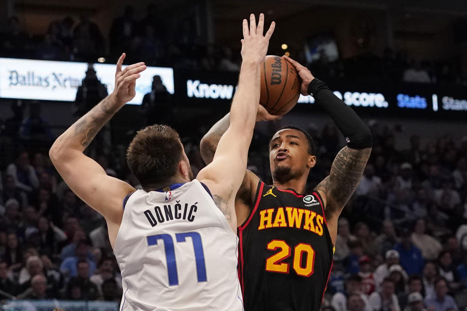 Atlanta Hawks forward John Collins (20) shoots against Dallas Mavericks guard Luka Doncic (77) during the second half of an NBA basketball game in Dallas, Wednesday, Jan. 18, 2023. Hawks won 130-122. (AP Photo/LM Otero)