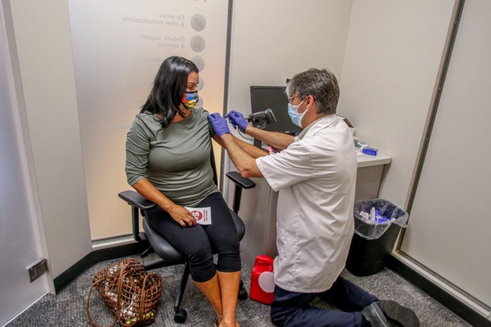 Rhonda McBurney of Providence gets her flu shot from pharmacist Joe Sayles at the CVS on Hope Street in Providence in September 2020.