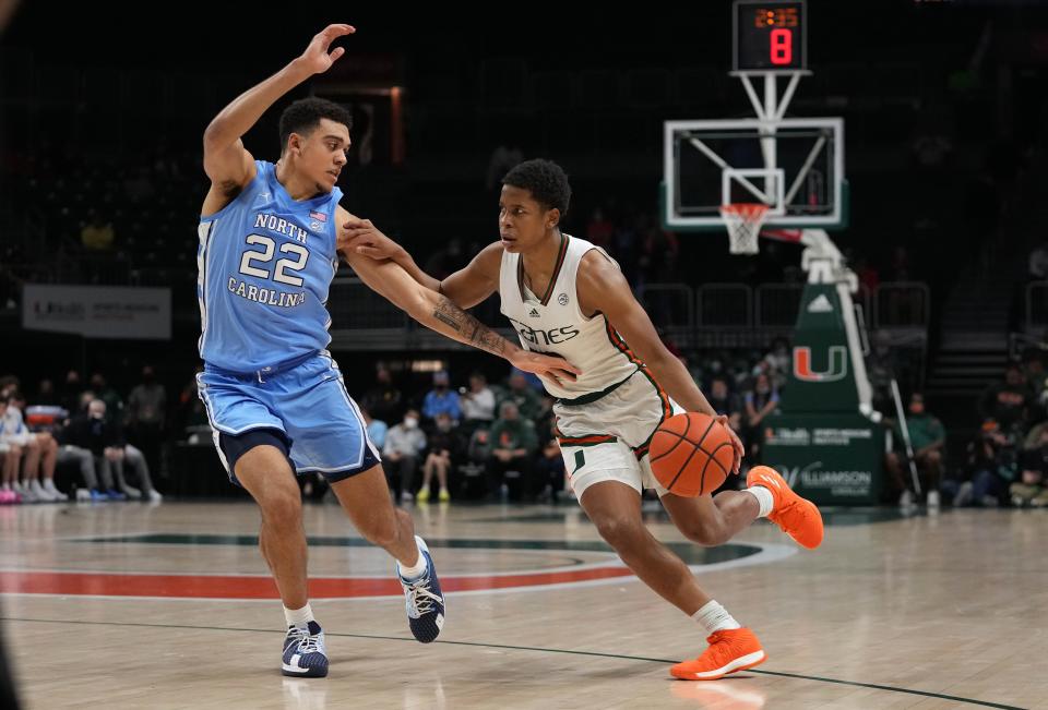 Jan 18, 2022; Coral Gables, Florida, USA; Miami Hurricanes guard Charlie Moore (3) drives the ball around North Carolina Tar Heels forward Justin McKoy (22) during the second half at Watsco Center.