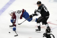 Colorado Avalanche right wing Mikko Rantanen, left, reaches for the puck in front of Los Angeles Kings center Trevor Moore (12) during the second period of an NHL hockey game Friday, May 7, 2021, in Los Angeles. (AP Photo/Marcio Jose Sanchez)