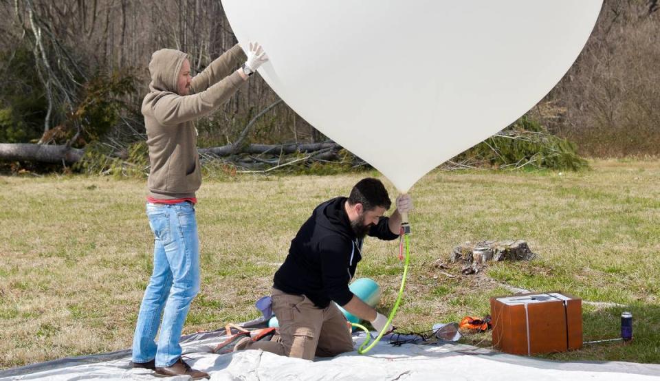 Brian Wallace, co-founder of Devil’s Logic, fills the weather balloon with helium while Adam Henley assists.