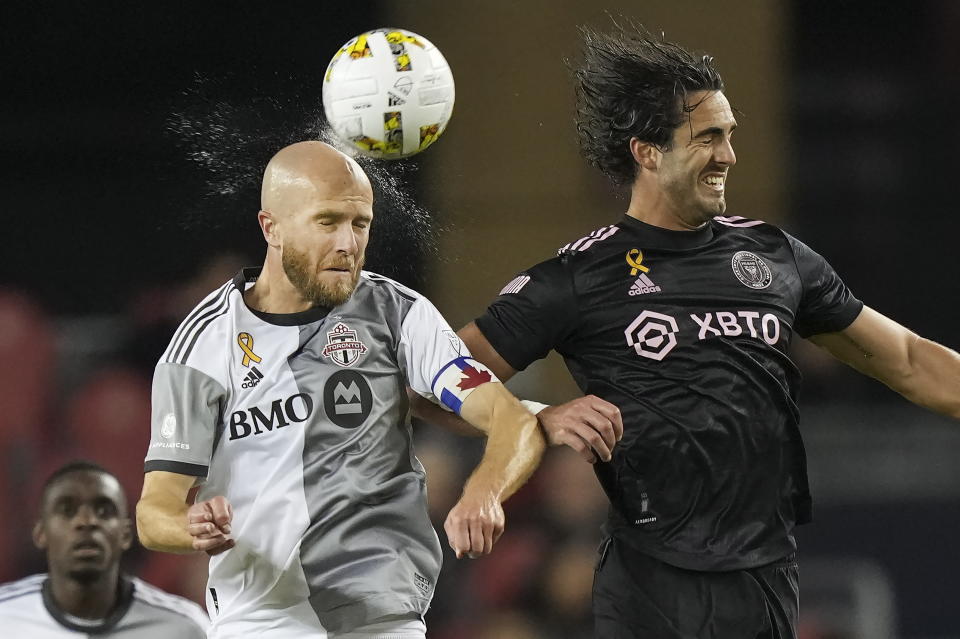 Toronto FC midfielder Michael Bradley, fron left, heads the ball as sweat comes off his head, next to Inter Miami forward Leonardo Campana during the second half of an MLS soccer match Friday, Sept. 30, 2022 in Toronto. (Nathan Denette/The Canadian Press via AP)