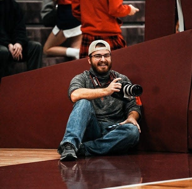 Zach Piatt smiles for the camera while covering a basketball game.