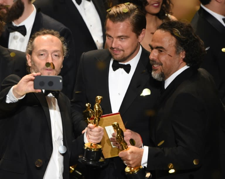 (L to R) Cinematographer Emmanuel Lubezki , actor Leonardo DiCaprio and director Alejandro Gonzalez Inarritu pose for a selfie with their awards on stage at the 88th Oscars