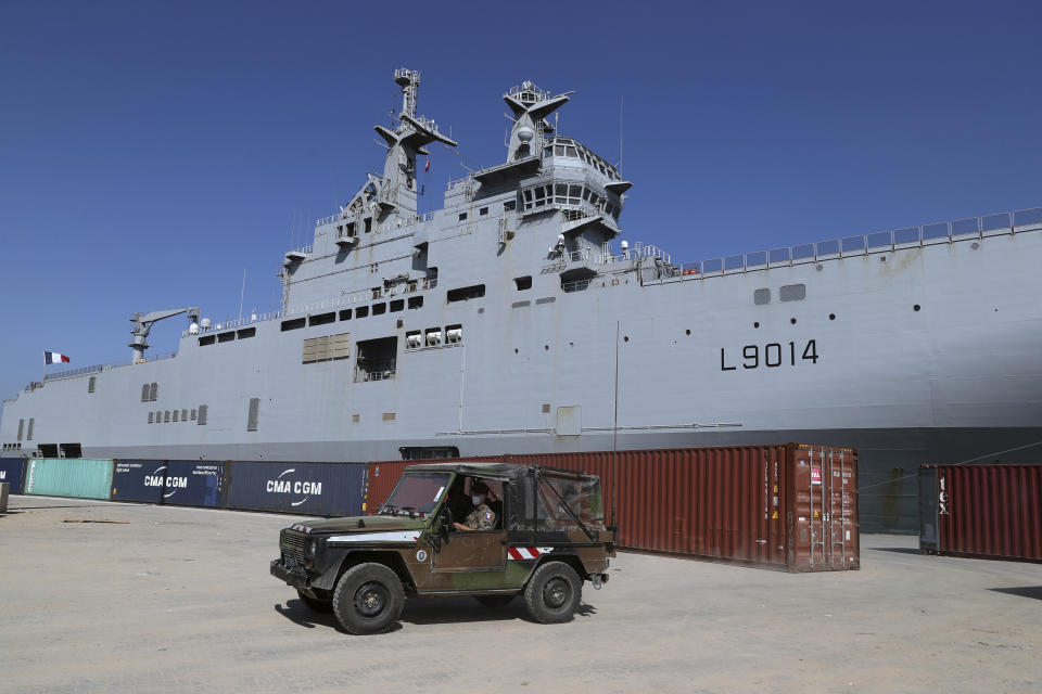 French military vehicle passes by the French Tonnerre helicopter carrier near the site of the Aug. 4 explosion that hit the seaport of Beirut, Lebanon, Saturday, Aug. 15, 2020. French investigators were playing a major role in the investigation as they were seen in boats and on the ground near the scene of the blast. (AP Photo/Bilal Hussein)