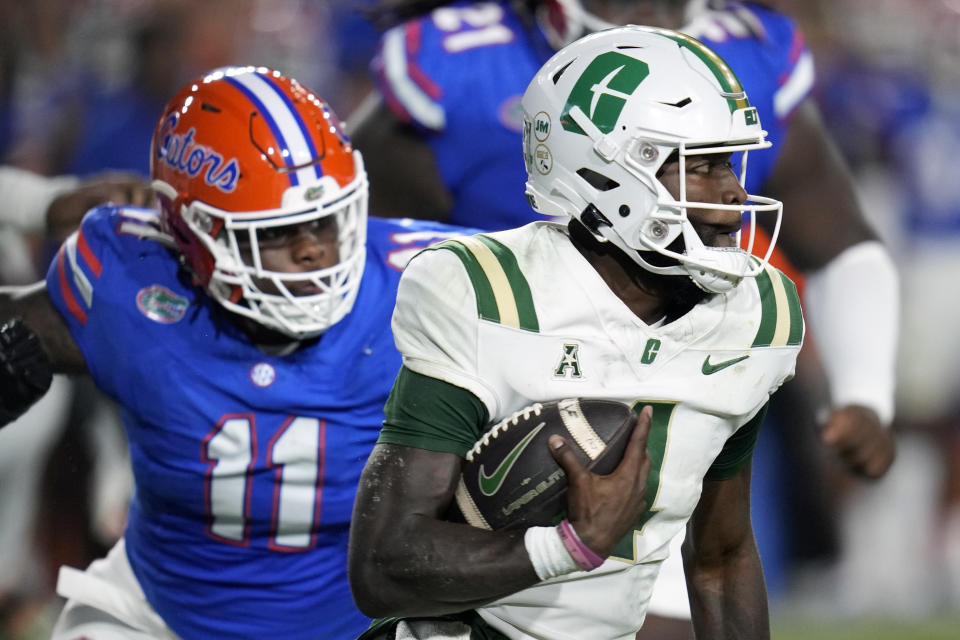 Charlotte quarterback Jalon Jones, right, scrambles past Florida defensive end Kelby Collins (11) during the first half of an NCAA college football game Saturday, Sept. 23, 2023, in Gainesville, Fla. (AP Photo/John Raoux)