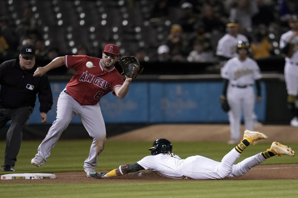 Oakland Athletics' Esteury Ruiz, right, steals third as Los Angeles Angels third baseman Mike Moustakas (8) waits for the throw during the sixth inning of a baseball game Friday, Sept. 1, 2023, in Oakland, Calif. (AP Photo/Godofredo A. Vásquez)