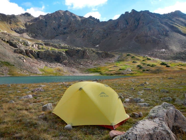 tent in front of mountains and lake