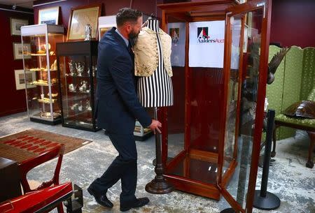 Julian Aalders from Aalders Auctions house moves a mannequin displaying a 250-year-old embroidered silk waistcoat that belonged to Captain James Cook back into a locked cabinet in Sydney, Australia, March 22, 2017. Picture taken March 22, 2017. REUTERS/David Gray