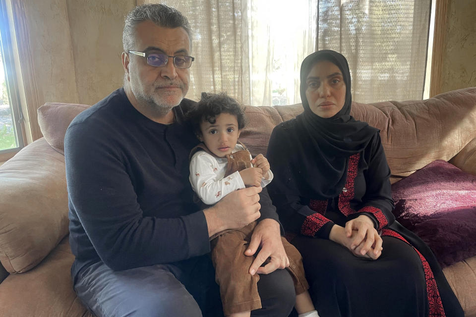 Jehad Adwan and Fatma Abumousa sit with their nearly 2-year-old son, Yaman, on a couch inside their home in Blaine, Minn., on Monday, Oct. 16, 2023. The family found out the day before that five of Abumousa's relatives were killed, and another five were injured, after a bomb hit her family's multigenerational home in Khan Younis, a southern city and decades-old refugee camp in Gaza, during the Israel-Hamas war. (AP Photo/Trisha Ahmed)