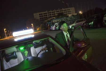 Kim Myong Chol, a taxi driver for Korea Kumgang Group (KKG), talks to passengers after dropping them at a hotel in central Pyongyang, North Korea October 8, 2015. REUTERS/Damir Sagolj