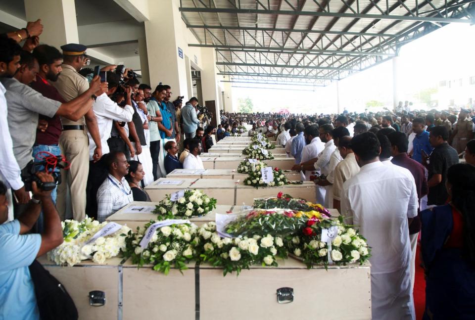 People gather around the coffins containing the bodies of people who died during a fire that broke out in a building housing foreign worker (REUTERS)