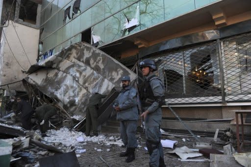 Afghan policemen stand guard at the site of a suicide attack at the gates of the Kabul City Centre shopping mall in Kabul on Monday. A Taliban suicide bomber targeted the popular mall, killing two guards and wounding at least two other people, officials say