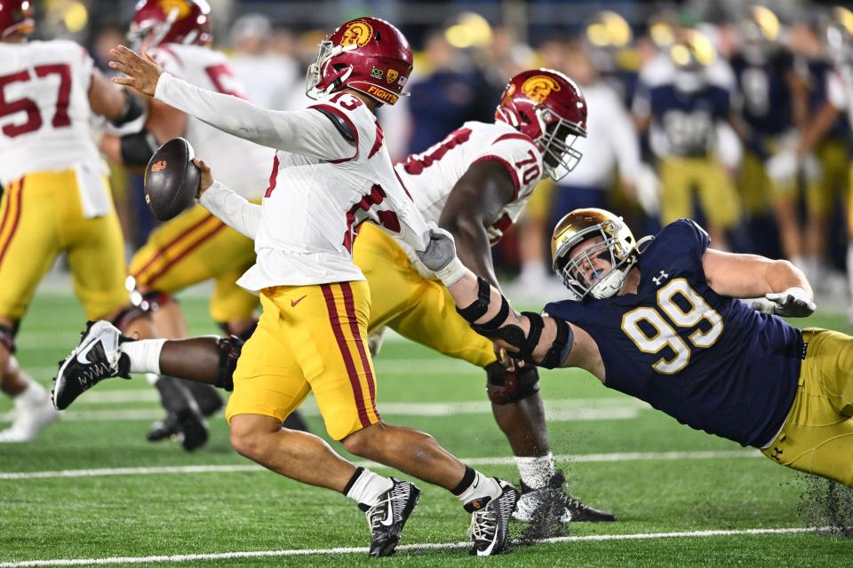 Oct 14, 2023; South Bend, Indiana, USA; Notre Dame Fighting Irish defensive lineman Rylie Mills (99) gets a hold of the jersey of USC Trojans quarterback Caleb Williams (13) in the fourth quarter at Notre Dame Stadium. Mandatory Credit: Matt Cashore-USA TODAY Sports